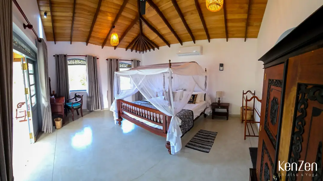 Suite Paradis de 40m² avec lit king-size et décoration épurée, bâtiment secondaire pour plus d'intimité.