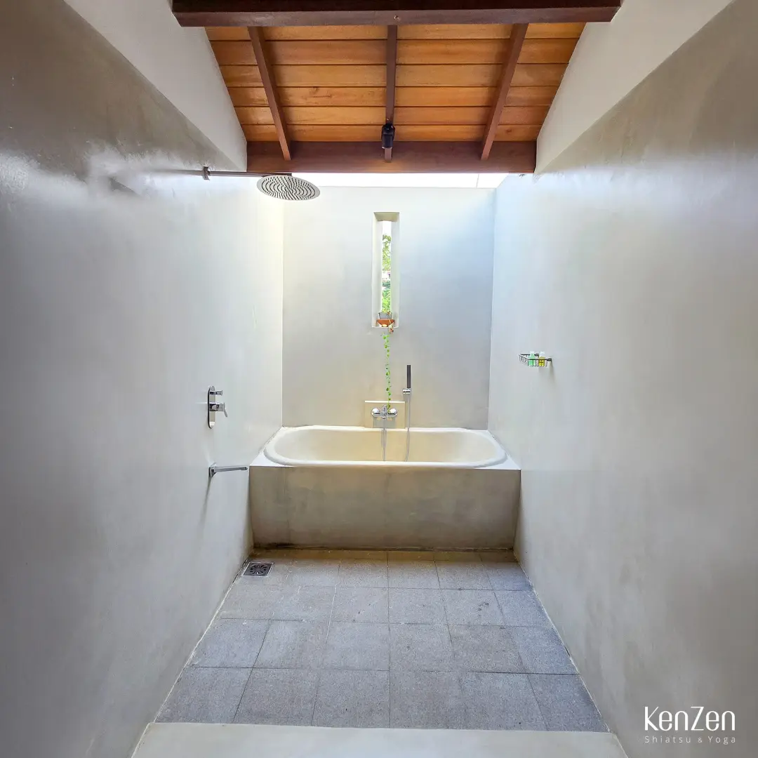 Baignoire à ciel ouvert et douche spacieuse dans la salle de bain de la suite Jasmin, avec rangements intégrés.