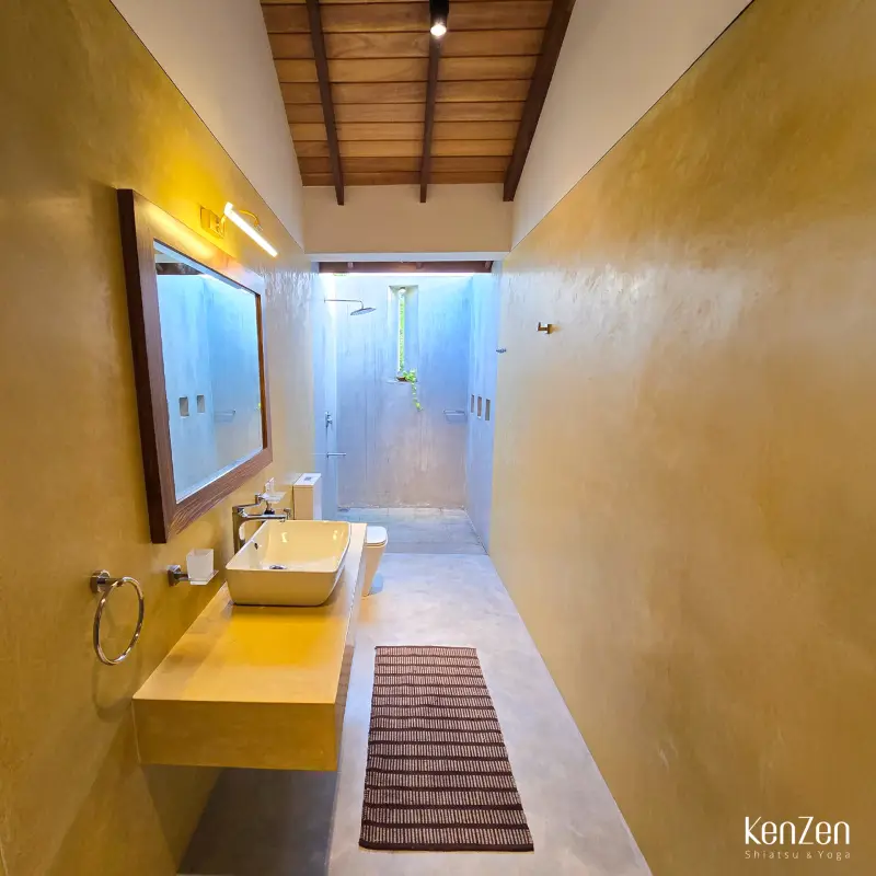 Douche à ciel ouvert de la chambre Hibiscus, ouverte sur la verdure pour une expérience de bain unique.